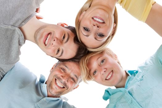 Happy family standing in a circle with their heads close together looking down at the camera with cheerful smiles