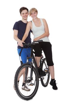 Fit healthy young couple who enjoy an active outdoor lifestyle standing with  bicycle