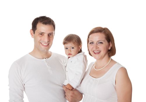 Smiling young family posing on a white studio background with the father holding his baby daughter on his arm