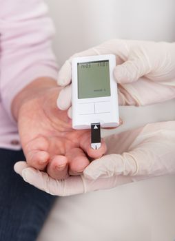 Close-up Of Doctor Checking Blood Sugar Level Indoor