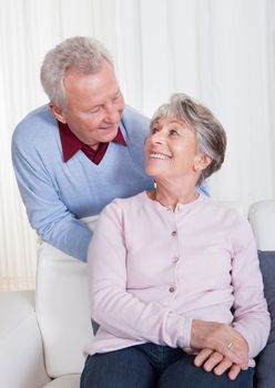 Portrait Of Happy Senior Couple Sitting On Couch