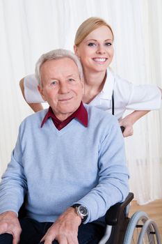 Caring Doctor Helping Handicapped Senior Patient Indoors