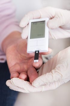 Close-up Of Doctor Checking Blood Sugar Level Indoor