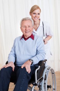 Caring Doctor Helping Handicapped Senior Patient Indoors