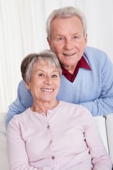 Portrait Of Happy Senior Couple Sitting On Couch