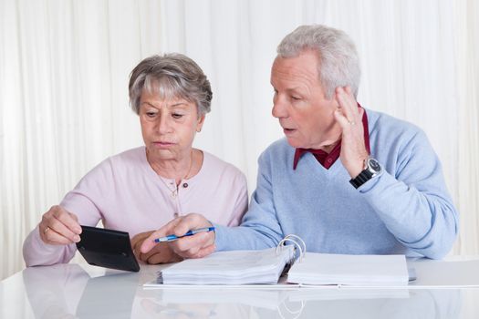 Stressed Senior Couple Calculating Budget At Home