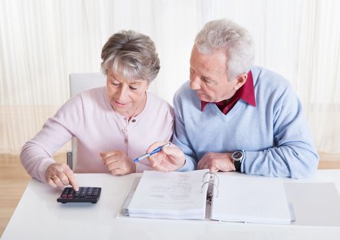 Photo of Senior Couple Calculating Budget At Home