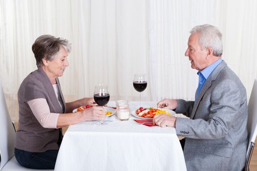 Portrait Of Senior Couple With Wine Glasses Sitting At A Restaurant