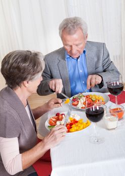 Portrait Of Senior Couple With Wine Glasses Sitting At A Restaurant