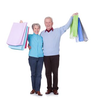 Portrait Of Happy Senior Couple Holding Shopping Bags