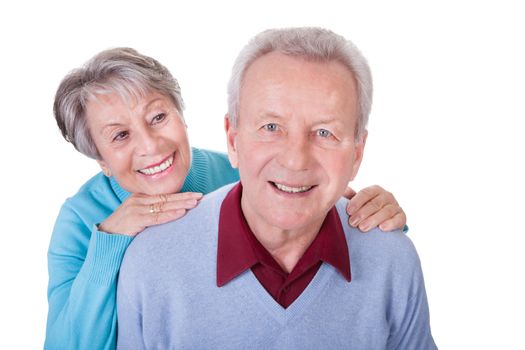 Portrait Of Senior Couple Enjoying Piggyback Isolated On White Background