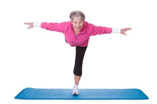 Senior Woman Standing On One Leg And Exercising Over White Background