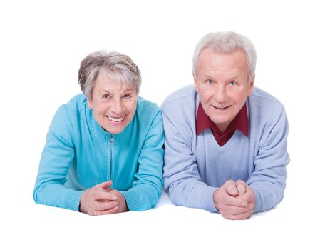 Portrait Of Happy Senior Couple Lying Over White Background