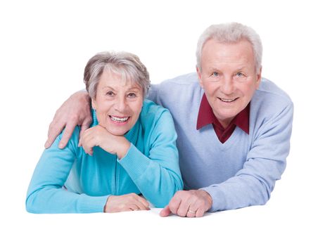 Portrait Of Happy Senior Couple Lying Over White Background