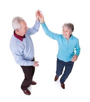 Portrait Of Senior Couple Dancing On White Background