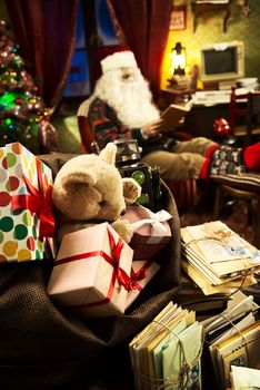 The messy desk of Santa Claus, he reading a book