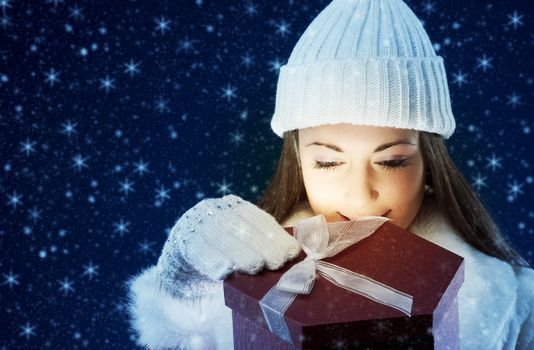 Happy young woman opening Christmas presents, copy space