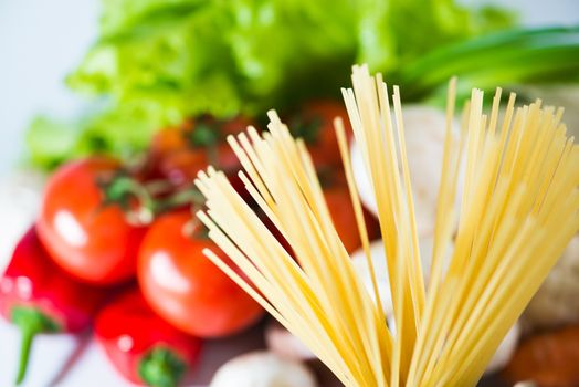 Raw Pasta spaghetti with vegetables close up