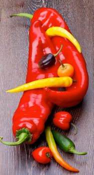 Arrangement of Various Ripe Ramiro, Chili and Jalapeno Peppers closeup on Wooden background