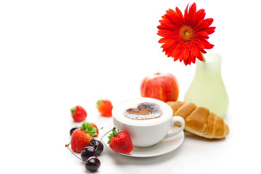 cappuccino in a cup in the shape of hearts,gerbera,apple,cherry,croissant and strawberries isolated on white