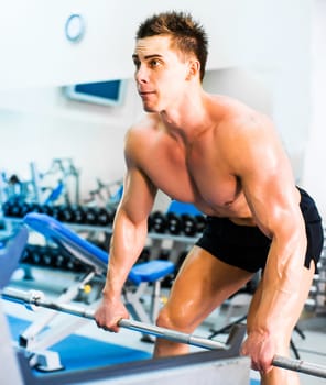 bodybuilder with barbell in gym