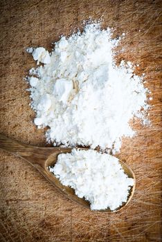 flour in a wooden spoon on cutting board