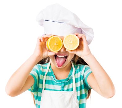little girl with two halves of lemon in the eyes shows tongue on a white background
