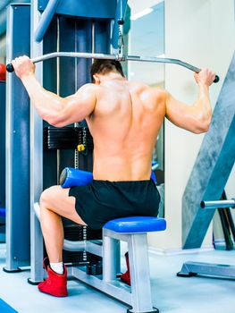 bodybuilder doing exercises on the simulator