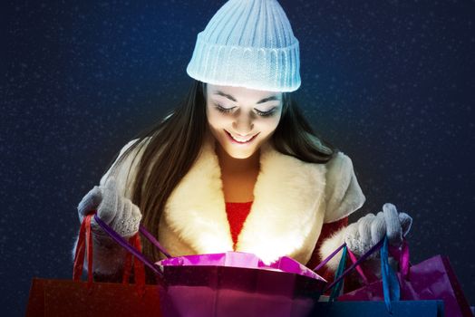 Young happy woman opening a shopping bag