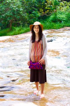 Biracial teen girl standing in shallow water, smiling