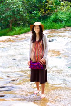 Biracial teen girl standing in shallow water, smiling