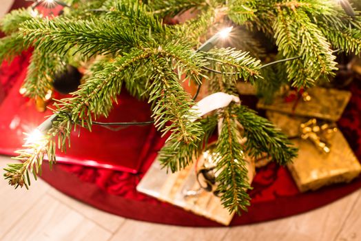 Colorful presents under the christmas tree with lights on