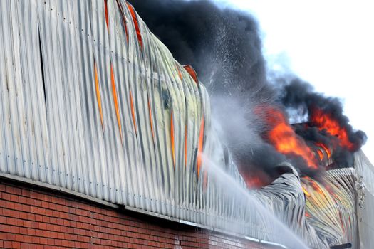 Warehouse building burning with intense flames 