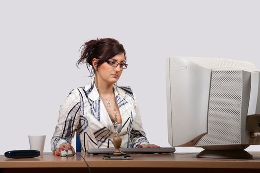 Young female office worker is concerned to work on computer