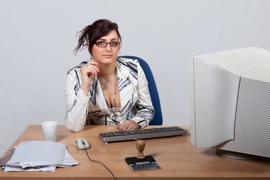 Young female office worker sitting behind a desk at a computer