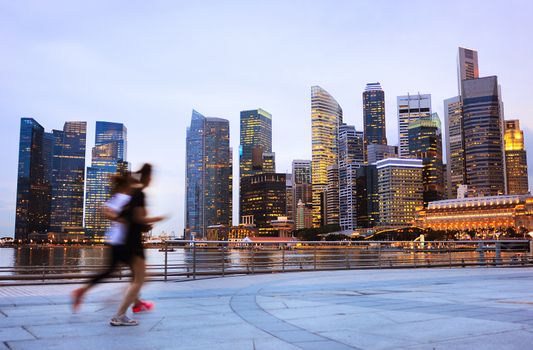 Two people jogging in front of Singapore downtown