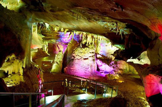 Sataplia cave in Georgia illuminated by colorful lights