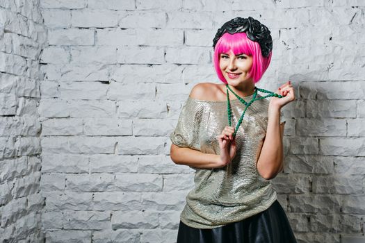 Attractive young girl with rim on head holding beads