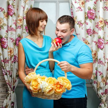 An attractive young couple. Girl feeding her boyfriend ripe apple