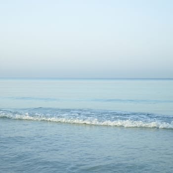 Beautiful turquoise wavy ocean with blue sky