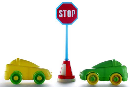 A couple cars behind stop road sign at white background