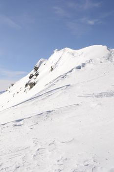 Candid off-piste ski slope in scenic background of high mountain peak