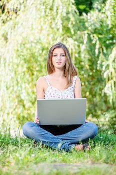 Pretty woman with laptop on summer day outdoor