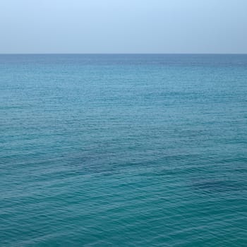 Beautiful turquoise wavy ocean with blue sky