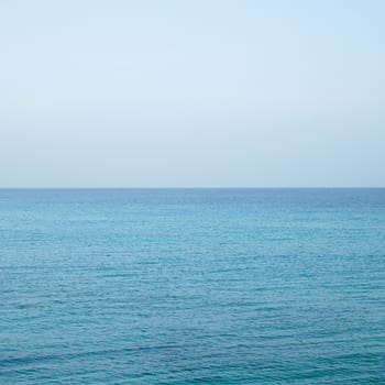 Beautiful turquoise wavy ocean with blue sky