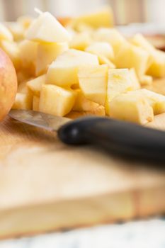 Knife and chopped apples on cutting board reading for use in recipes