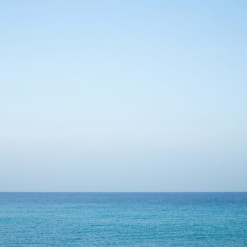 Beautiful turquoise wavy ocean with blue sky