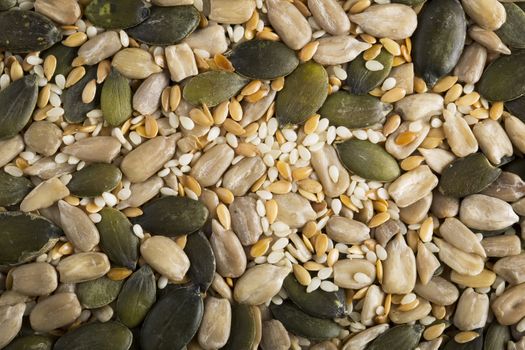 Mixed healthy seeds food background containing pumpkin seeds, sesame seeds and sunflower seeds.