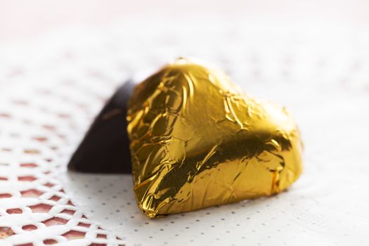 Two hearts, one wrapped in gold foil, one hidden.
