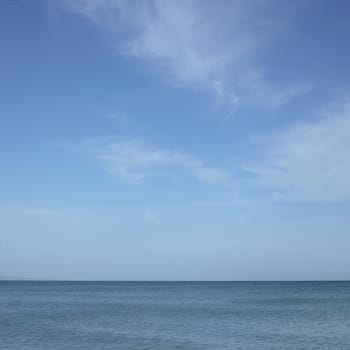 Turquoise ocean with blue sky and white clouds